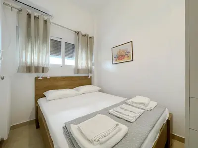 a white room with a bed with towels on it at SOKOS Residence, 4' walk from Syngrou-Fix Metro in Athens