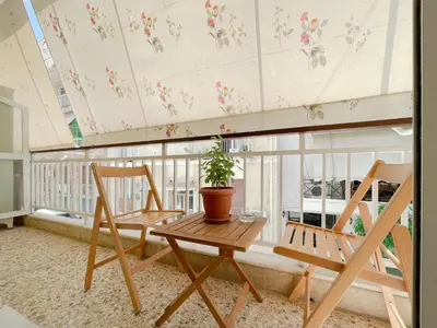 a balcony with two chairs and a table and a plant at SOKOS Residence, 4' walk from Syngrou-Fix Metro in Athens