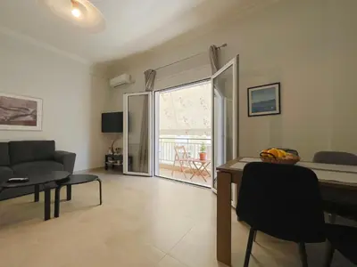 a living room with a couch and a table at SOKOS Residence, 4' walk from Syngrou-Fix Metro in Athens