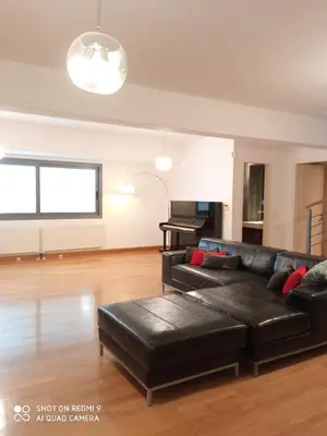 a living room with a black leather couch and a piano at Ultra-Modern Living, Luxe 4BR with Private Outdoor Pool in Athens