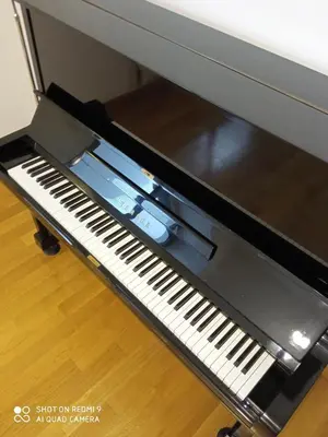 a black piano sitting on top of a table at Ultra-Modern Living, Luxe 4BR with Private Outdoor Pool in Athens