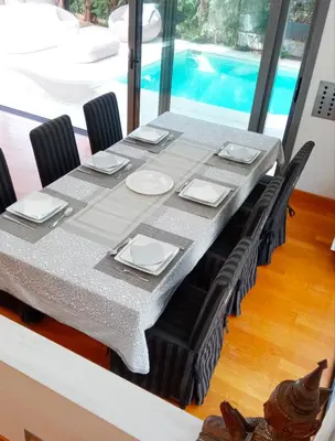 a dining room table with chairs and a table cloth at Ultra-Modern Living, Luxe 4BR with Private Outdoor Pool in Athens