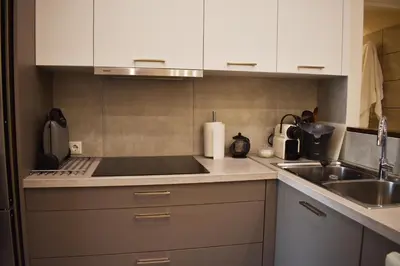 a kitchen with white cabinets and a sink at Skip Away from the Acropolis Museum by Athenian Homes in Athens