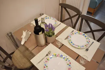 a table with two plates and a bottle of wine at Skip Away from the Acropolis Museum by Athenian Homes in Athens
