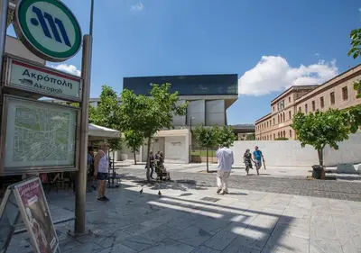 a group of people standing on a street at Skip Away from the Acropolis Museum by Athenian Homes in Athens