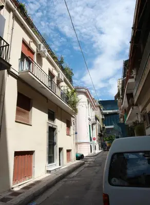 a car parked on a street next to a building at Skip Away from the Acropolis Museum by Athenian Homes in Athens