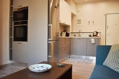 a kitchen and a living room with a couch and a table at Skip Away from the Acropolis Museum by Athenian Homes in Athens