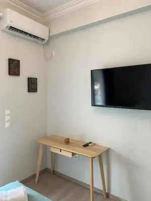 a room with a table and a flat screen tv on the wall at Skip Away from the Acropolis Museum by Athenian Homes in Athens