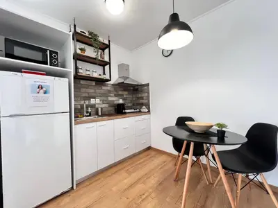 a kitchen with a table and a refrigerator at Athena Βright & New Studio - 25' walk to the Acropolis in Athens