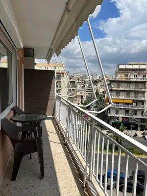 a balcony with a table and a view of a city at Athena Βright & New Studio - 25' walk to the Acropolis in Athens