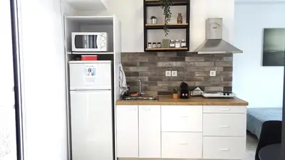 a kitchen with white cabinets and a refrigerator at Hermes New & Comfy Studio - 25' walk to the Acropolis in Athens