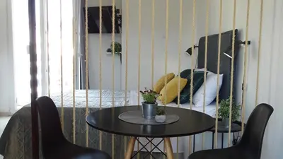 a table with two chairs and a table with flowers on it at Hermes New & Comfy Studio - 25' walk to the Acropolis in Athens