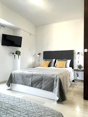 a bedroom with a large bed and a flat screen tv at Hermes New & Comfy Studio - 25' walk to the Acropolis in Athens