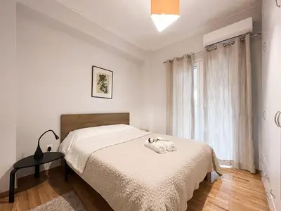 a white bedroom with a bed and a window at SOKOS Residence, 5' walk from Acropolis Museum in Athens