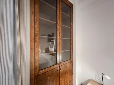 a wooden cabinet in a room with a bed at SOKOS Residence, 5' walk from Acropolis Museum in Athens