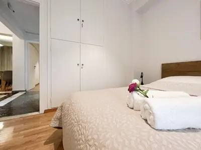 a white bedroom with a bed with flowers on it at SOKOS Residence, 5' walk from Acropolis Museum in Athens