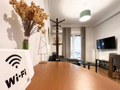 a living room with a wooden table and a cross at SOKOS Residence, 5' walk from Acropolis Museum in Athens
