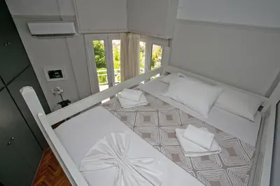 a small room with two beds with white pillows at Erato by Heloni Apartments in Athens