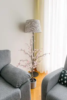 a living room with a lamp and a couch and a tree at Erato by Heloni Apartments in Athens