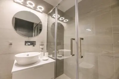 a bathroom with a sink and a shower with a mirror at Erato by Heloni Apartments in Athens
