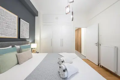 a bedroom with a large white bed with towels on it at Elegant Suite by CloudKeys in Athens