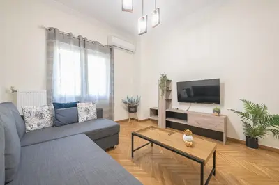 a living room with a couch and a tv at Elegant Suite by CloudKeys in Athens
