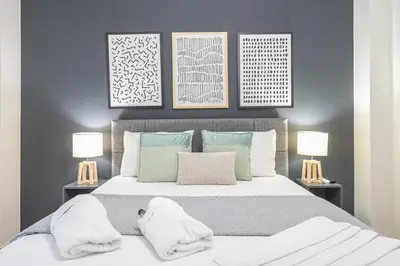 a bedroom with a large bed with two lamps at Elegant Suite by CloudKeys in Athens