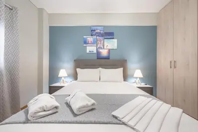 a bedroom with a bed with two towels on it at Stylish Suite by CloudKeys in Athens
