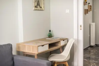 a desk in a room with a couch and a chair at Stylish Suite by CloudKeys in Athens