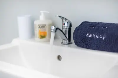 a bathroom counter with a sink and a towel at Stylish Suite by CloudKeys in Athens