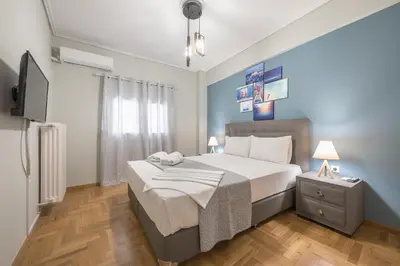 a bedroom with a large bed and a television at Stylish Suite by CloudKeys in Athens