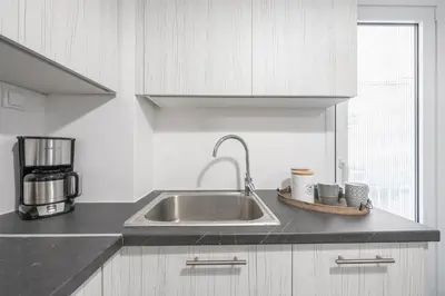 a kitchen with a sink and a coffee maker at Stylish Suite by CloudKeys in Athens