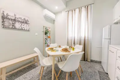 a kitchen and dining room with a white table and chairs at Ourania by Heloni Apartments in Athens