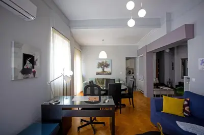 a living room with a blue couch and a table at Ourania by Heloni Apartments in Athens