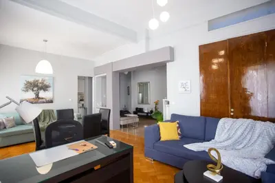 a living room with a blue couch and a table at Ourania by Heloni Apartments in Athens