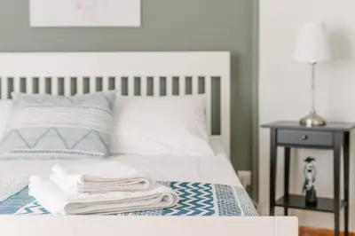 a bed with white sheets and towels on it at Ourania by Heloni Apartments in Athens
