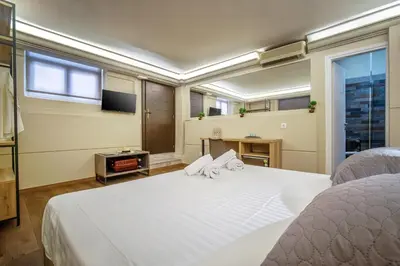 a bedroom with a large white bed and a window at Karma Athens in Athens