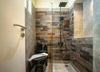 a bathroom with a glass shower with a toilet at Karma Athens in Athens
