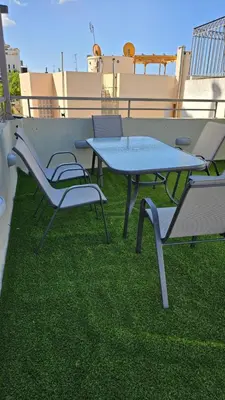 a table and chairs on a roof with grass at Karma Athens in Athens