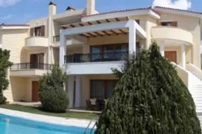 a large house with a swimming pool in front of it at Seaside Villa Lagonisi in Kalívia Thorikoú