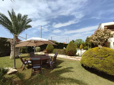 a table and chairs with an umbrella in a yard at Seaside Villa Lagonisi in Kalívia Thorikoú
