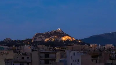 a view of a mountain at night with buildings at Acropol Studio Loft with amazing view & terrace in Athens
