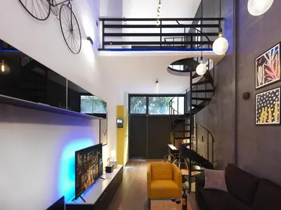 a living room with a spiral staircase and a tv at 200 Mb fibre remote workers' Dreamhouse in Athens
