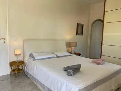 a bedroom with a white bed with a hat on it at PortoRafti seaview garden Villa in Porto Rafti