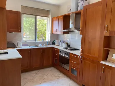 a kitchen with wooden cabinets and a stove top oven at PortoRafti seaview garden Villa in Porto Rafti