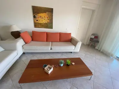 a living room with a couch and a coffee table at PortoRafti seaview garden Villa in Porto Rafti