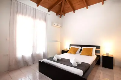 a bedroom with a large bed with yellow pillows at markopoulo-apartmets in Markopoulo