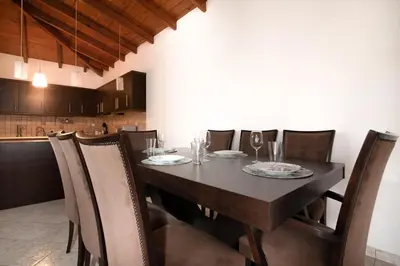 a dining room with a black table and chairs at markopoulo-apartmets in Markopoulo