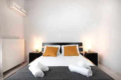 a bedroom with a bed with two pillows and two lamps at markopoulo-apartmets in Markopoulo