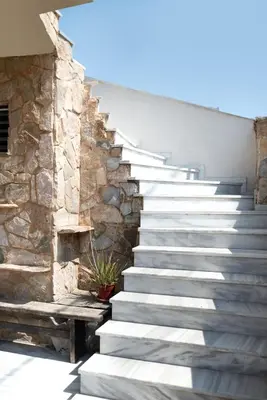 a set of stairs next to a stone wall at markopoulo-apartmets in Markopoulo